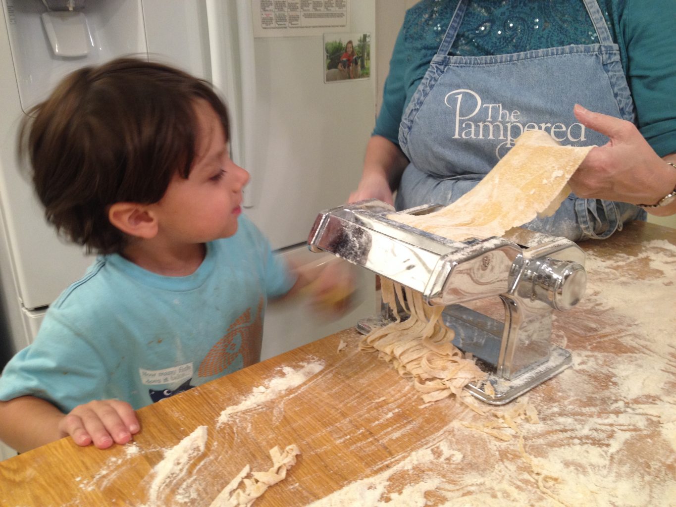 child rolling pasta